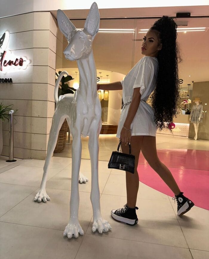 Megan Ibiza luxury escort posing with a statue of a dog Megan Ibiza luxury escort posing with a statue of a dog